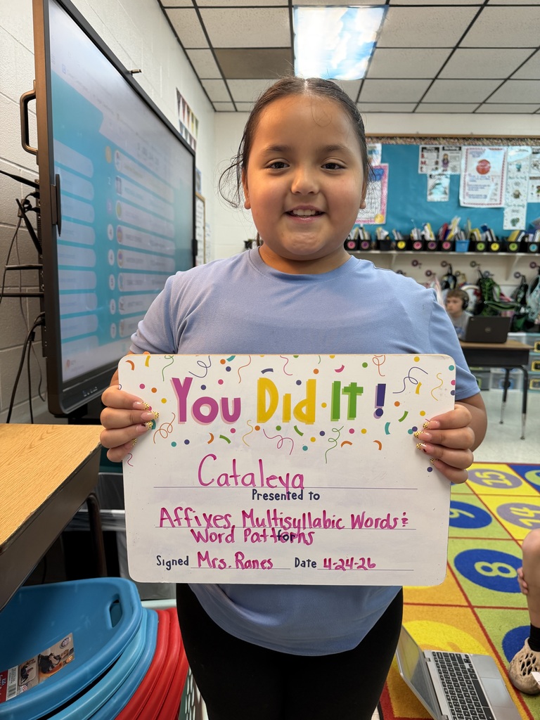 smiling child holding a celebration board