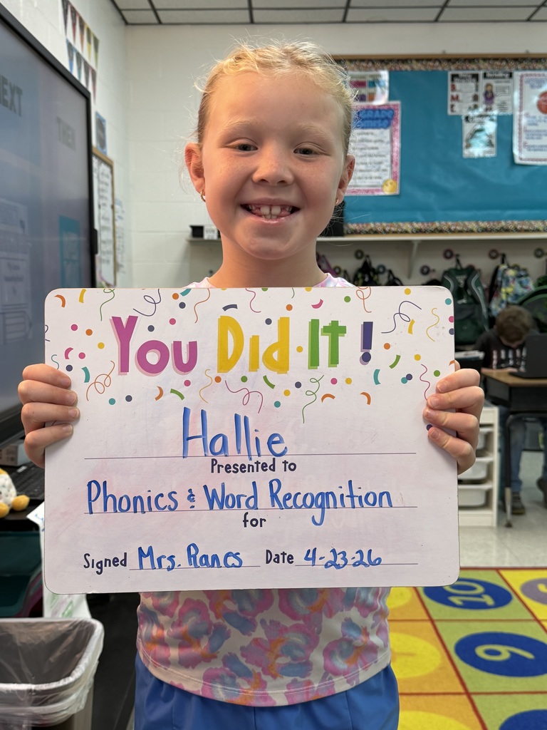 smiling child holding a celebration board