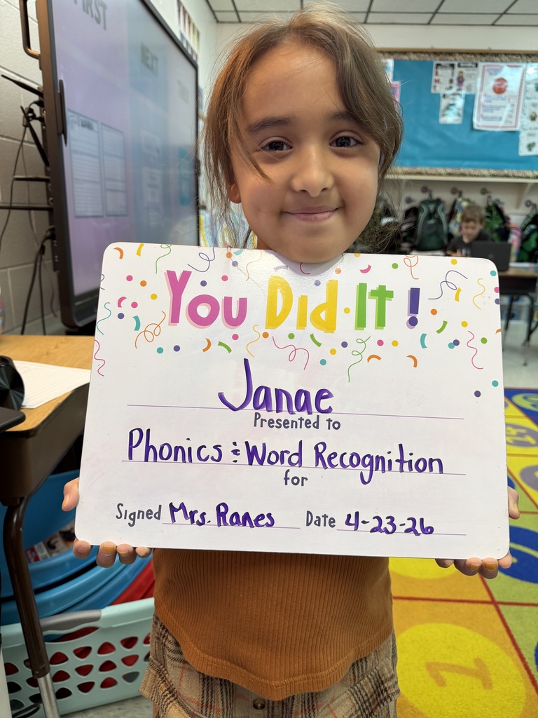smiling child holding a celebration board
