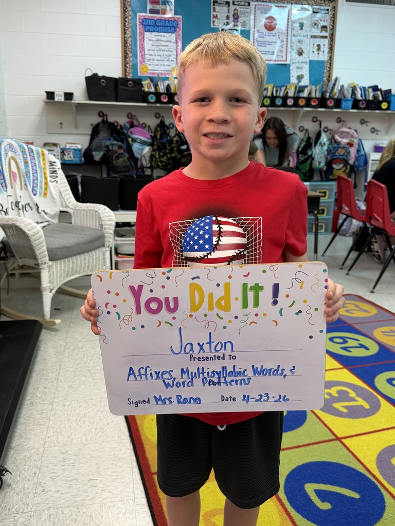 smiling child holding a celebration board