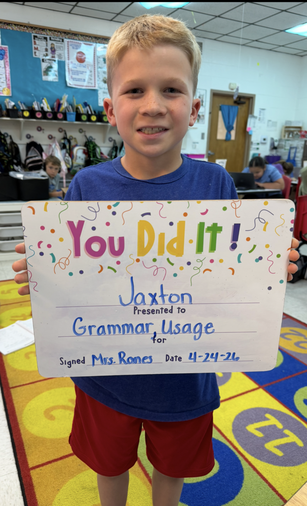 smiling child holding a celebration board