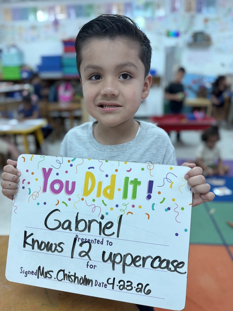 Smiling student holding celebration board