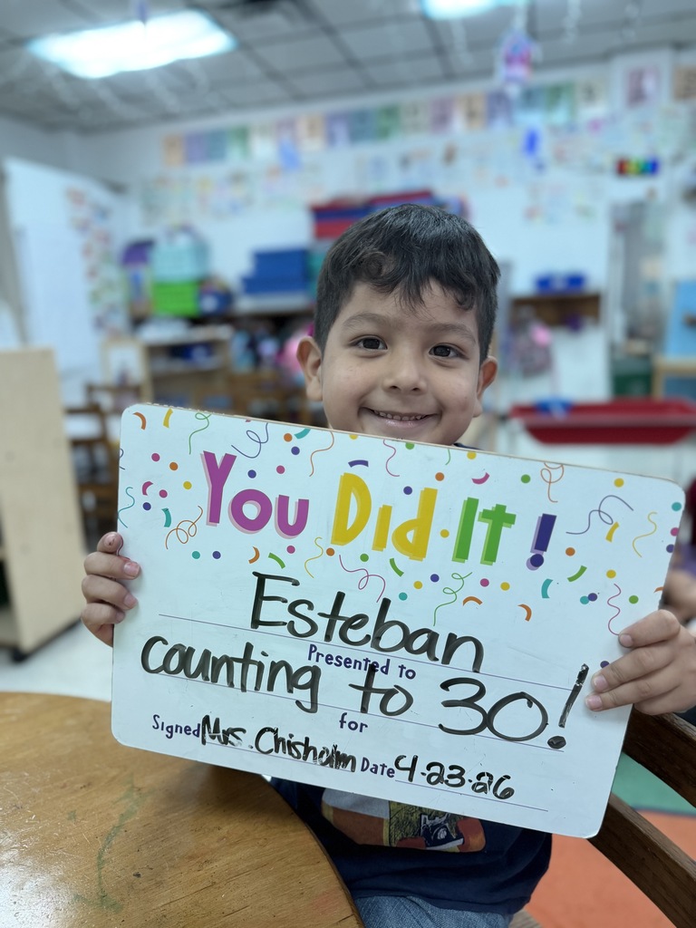 Smiling student holding celebration board