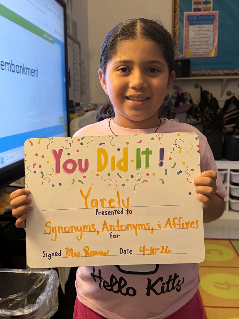 Smiling student holding celebration board
