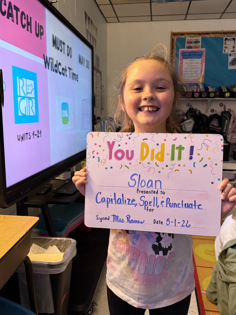 Smiling student holding celebration board