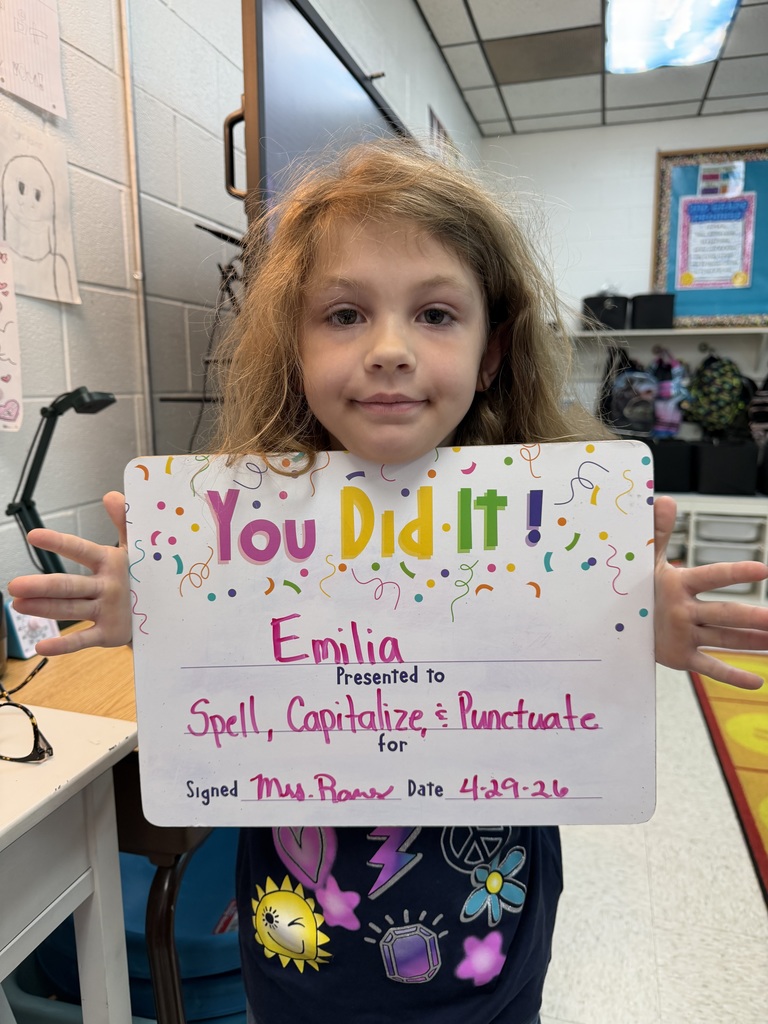 Smiling student holding celebration board