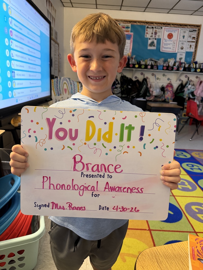 Smiling student holding celebration board