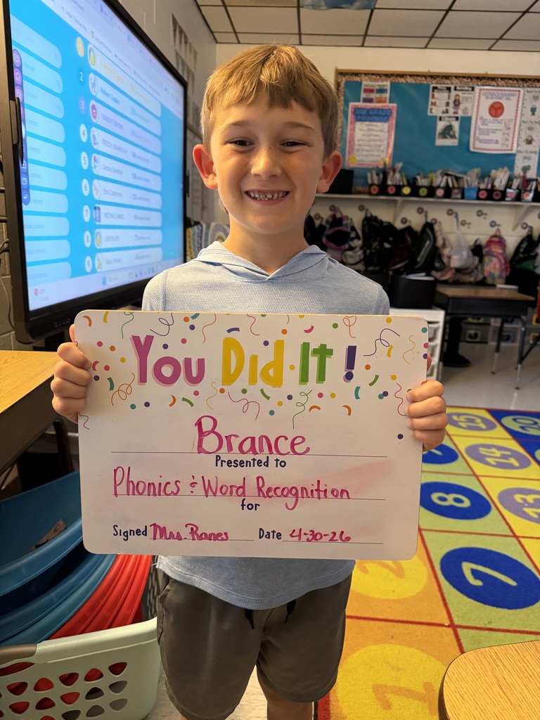 Smiling student holding celebration board
