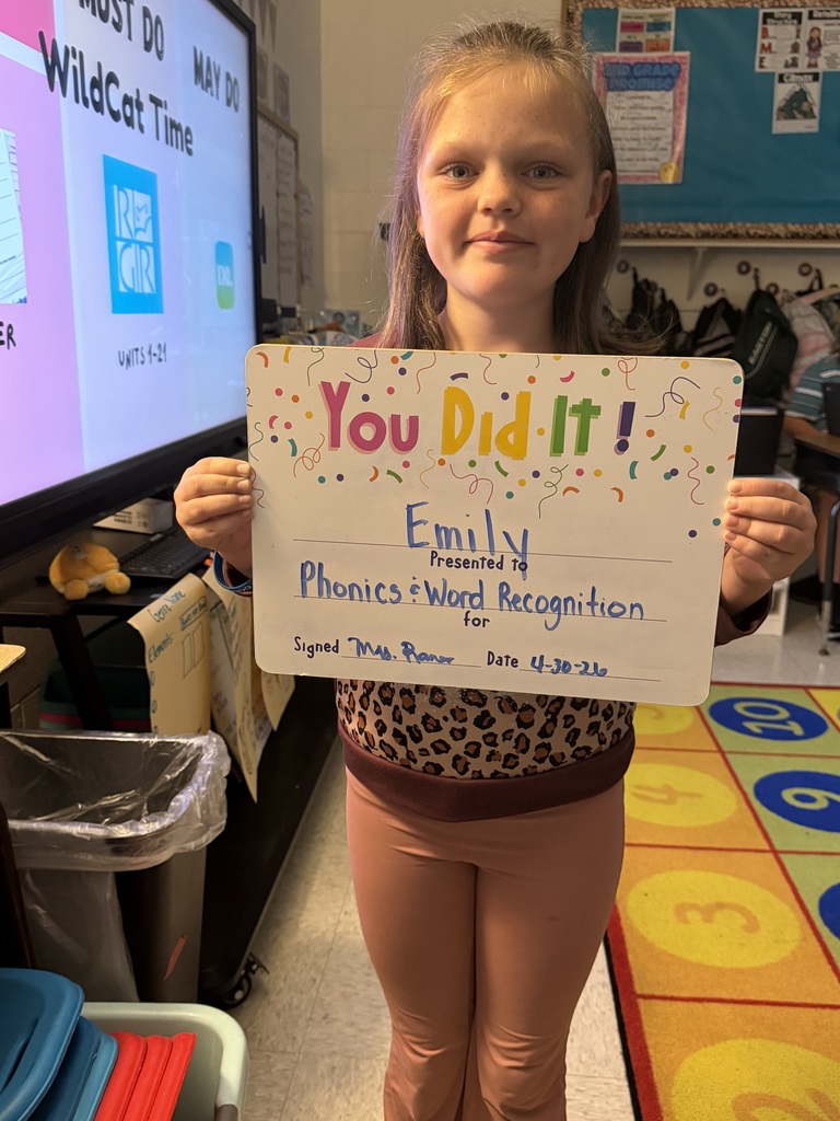 Smiling student holding celebration board