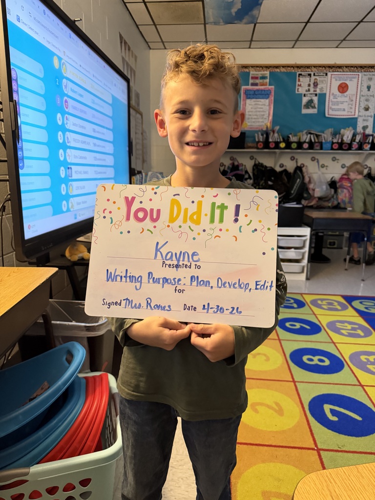 Smiling student holding celebration board