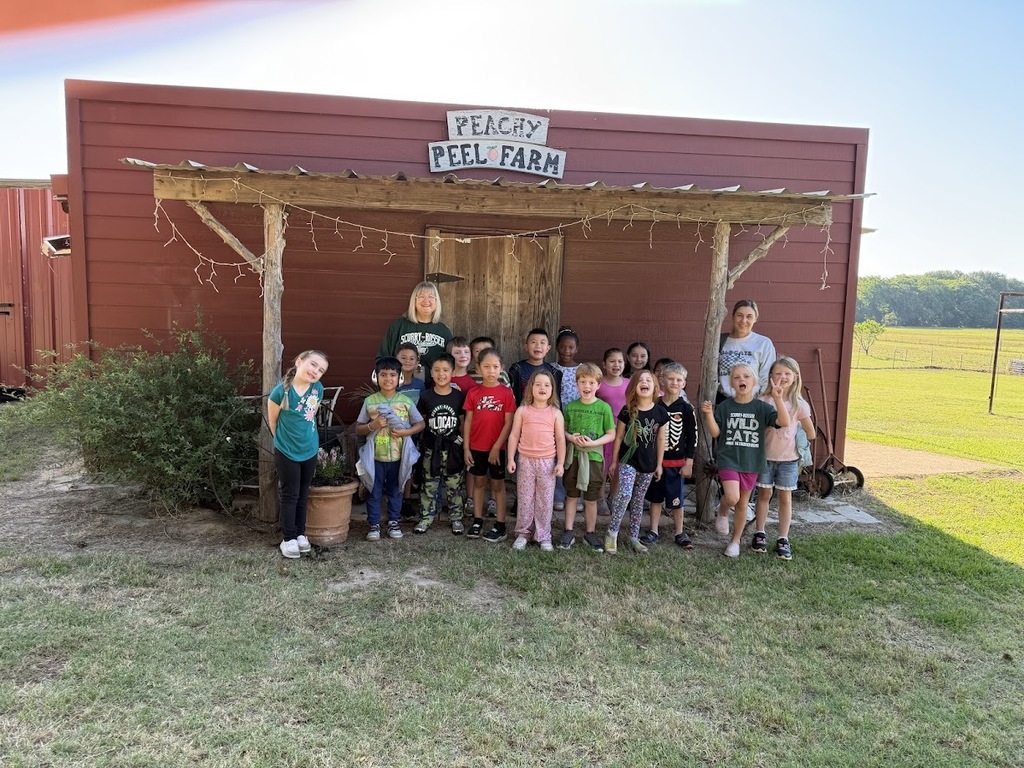 group photo of students and teacher in front of the red barn at Peachy Peel Farm