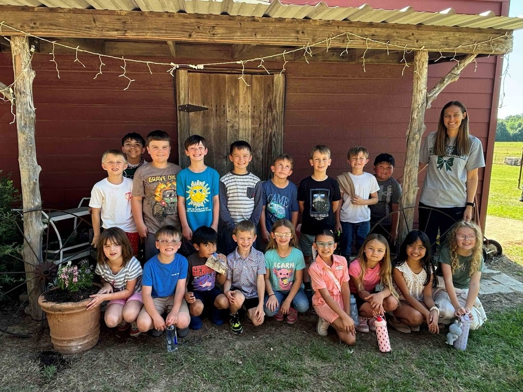group photo of students and teacher in front of the red barn at Peachy Peel Farm