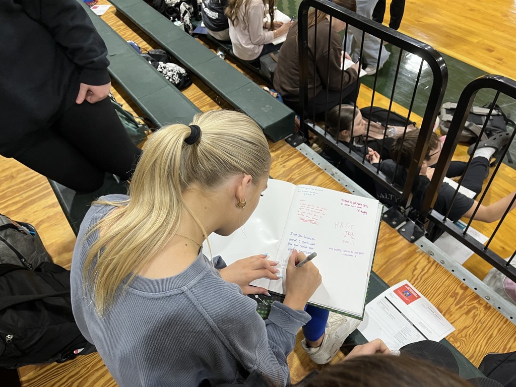 a picture of a girl signing a yearbook