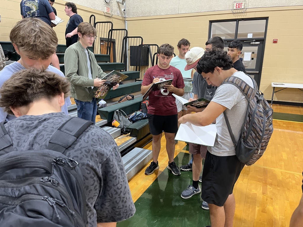 group of male students signing yearbooks