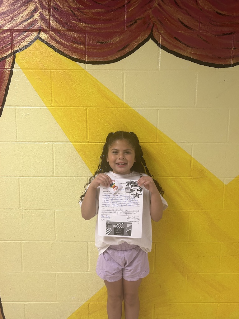 smiling child holding highlighted accomplishment