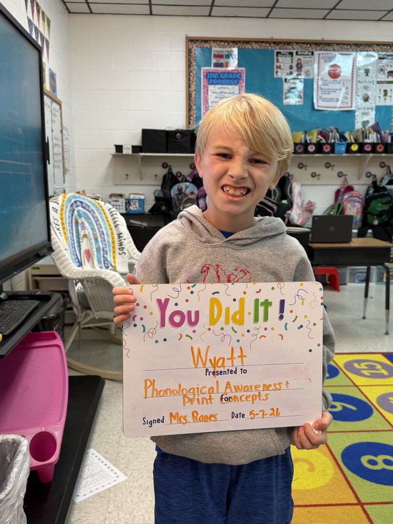 smiling child holding highlighted accomplishment