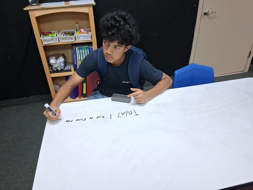 Student writing on table top