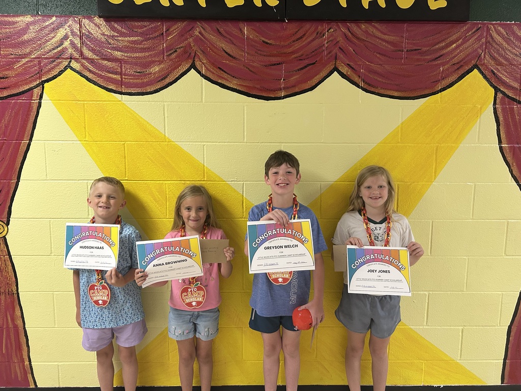 Four smiling children holding certificates of achievement