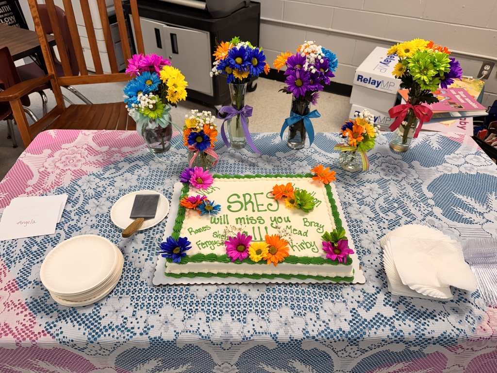 table with decorated cake and flower arrangements