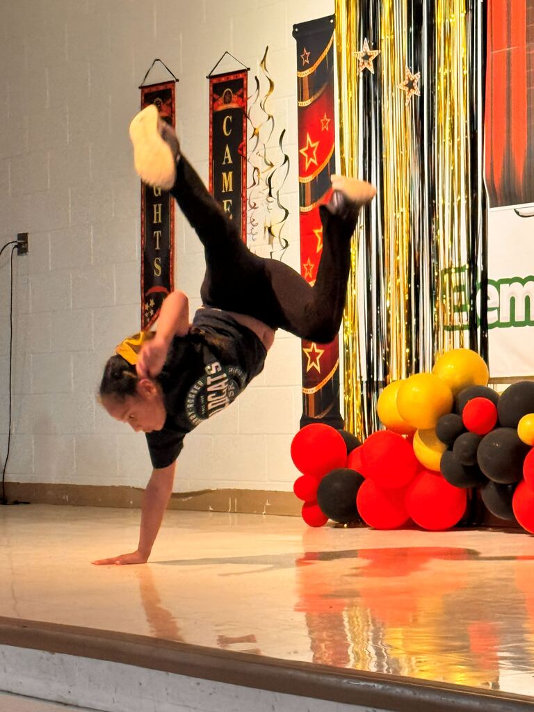 felmale student do a handstand on one hand