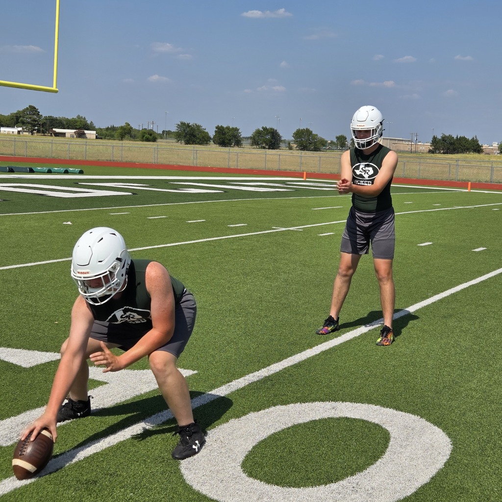 two male football players practicing in shorts, shirt and helmet