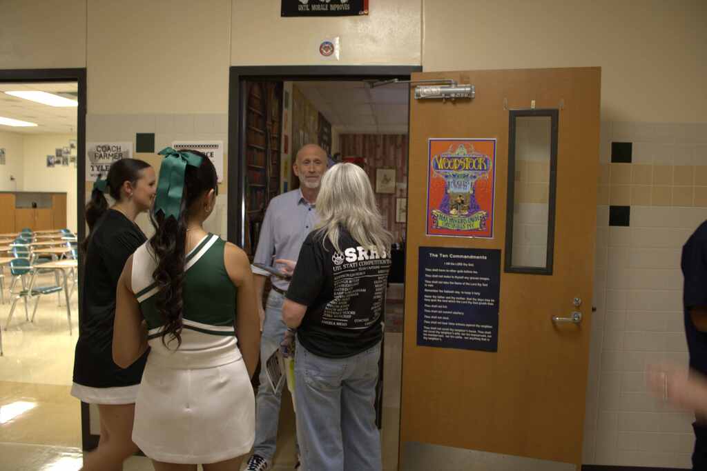 teacher, two female students and a parent at high school meet the teacher