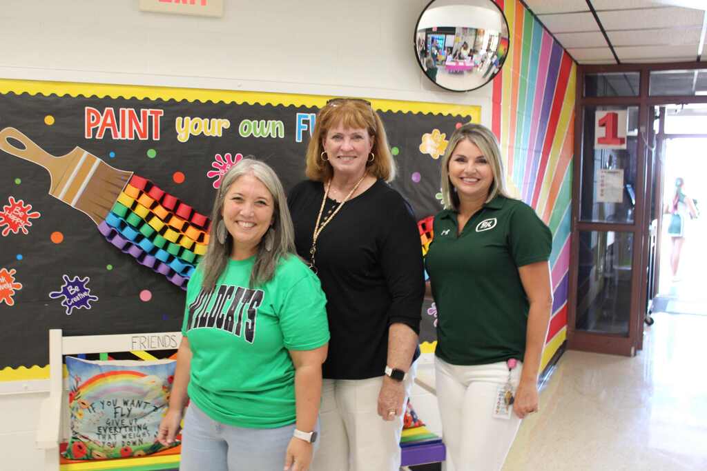 picture of Ashley Sheppard, Lori Blaylock and Kandy Shirey standing in front of bulletin board