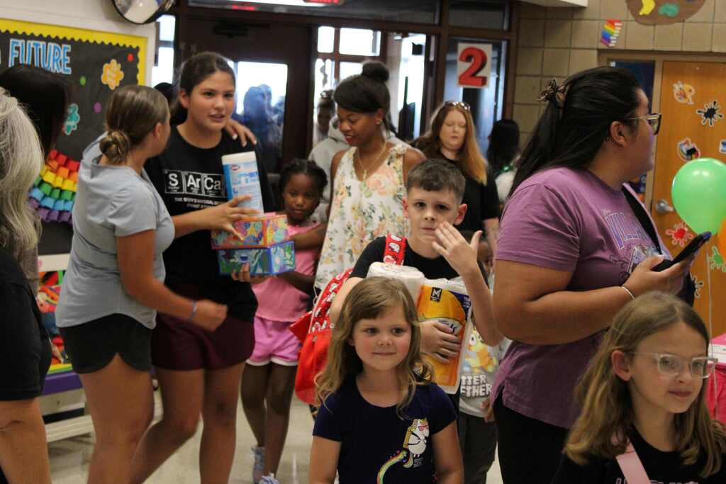 elementary parents , students and guest walking in the building for meet the teacher
