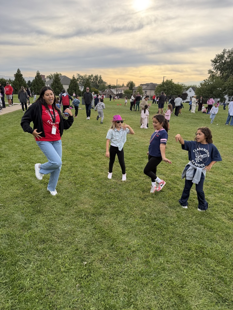 People in various clothing, including a woman in a jacket and pants, run on a grassy field.