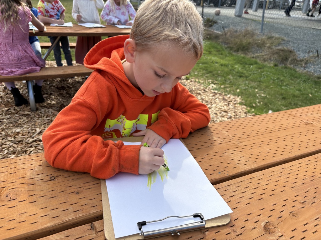 Students at Lyman Elementary participate in Farm to School lessons with instructor Miles Lane, learning about leaves and composting through hands-on garden activities.