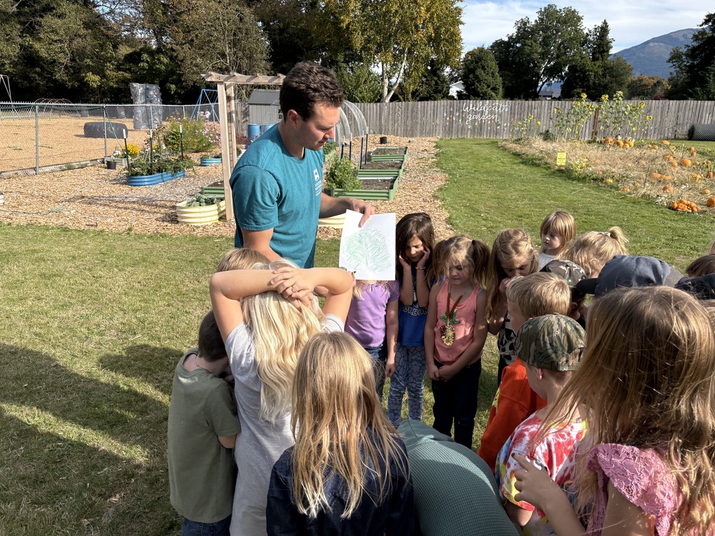Students at Lyman Elementary participate in Farm to School lessons with instructor Miles Lane, learning about leaves and composting through hands-on garden activities.