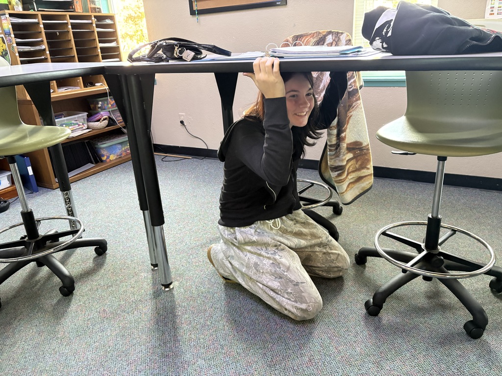 Students at State Street High School crouch under desks and tables during the Great ShakeOut earthquake drill, practicing “Drop, Cover, and Hold On” procedures.