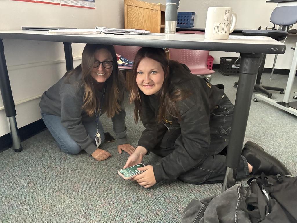 Students at State Street High School crouch under desks and tables during the Great ShakeOut earthquake drill, practicing “Drop, Cover, and Hold On” procedures.