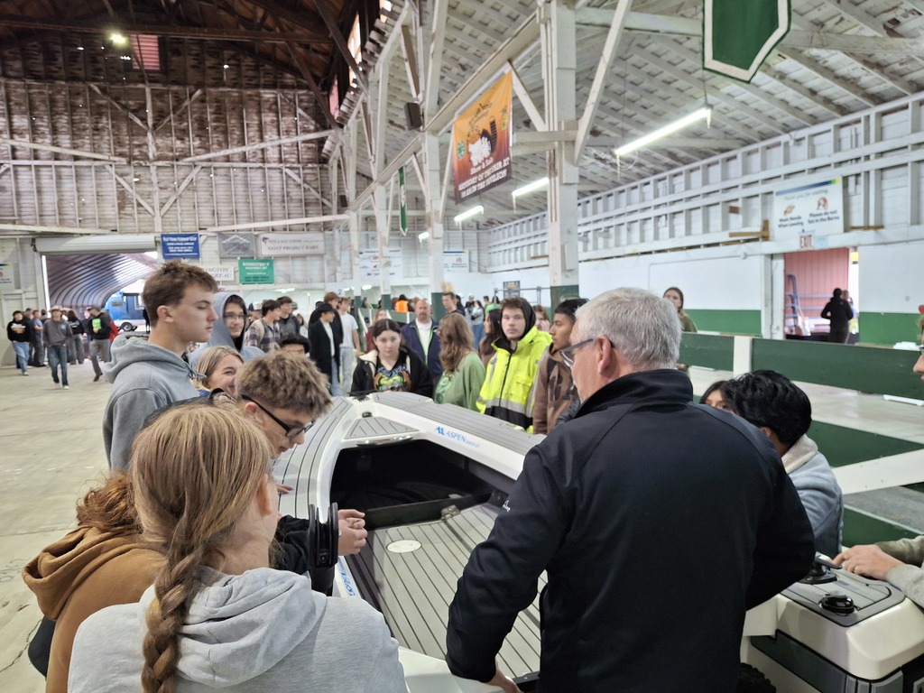 Students from Sedro-Woolley and State Street High Schools stand near a tender boat from Aspen Power Catamarans while learning about lightweight boat construction technologies.