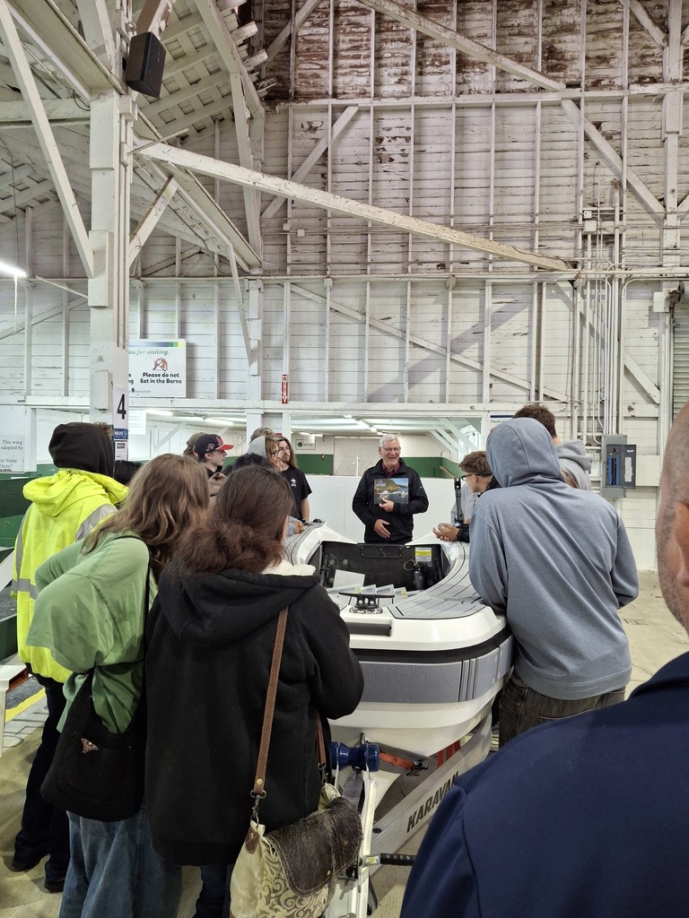 Students from Sedro-Woolley and State Street High Schools stand near a tender boat from Aspen Power Catamarans while learning about lightweight boat construction technologies.