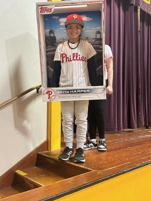 A Big Lake Elementary 6th grader, Bentley Zachmeyer, smiles in his Halloween costume dressed as Philadelphia Phillies player Bryce Harper. He’s framed inside a life-size Topps baseball card cutout.
