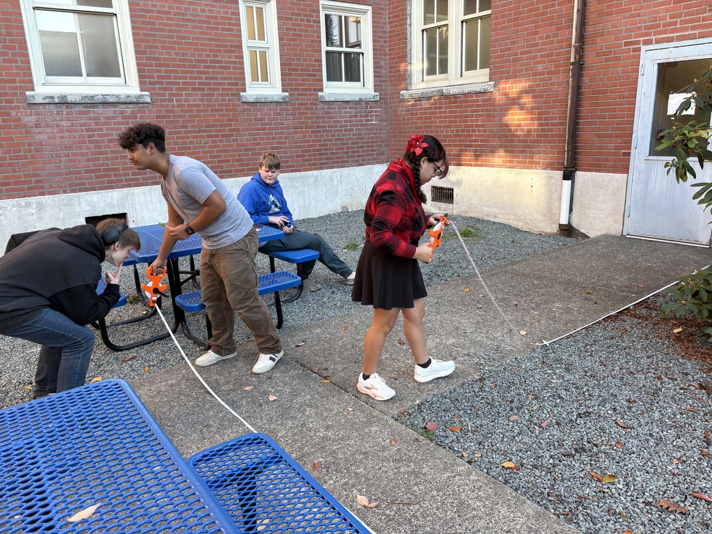 Geometry in the Wild! Students in Sedro-Woolley High School’s Geometry in Construction class took their learning outside today to measure the area of the concrete courtyard by the cafeteria. 🧮📏 Hands-on lessons like this help students see how math concepts apply in real-world construction projects—right here on campus! #RootedInSW #HandsOnLearning