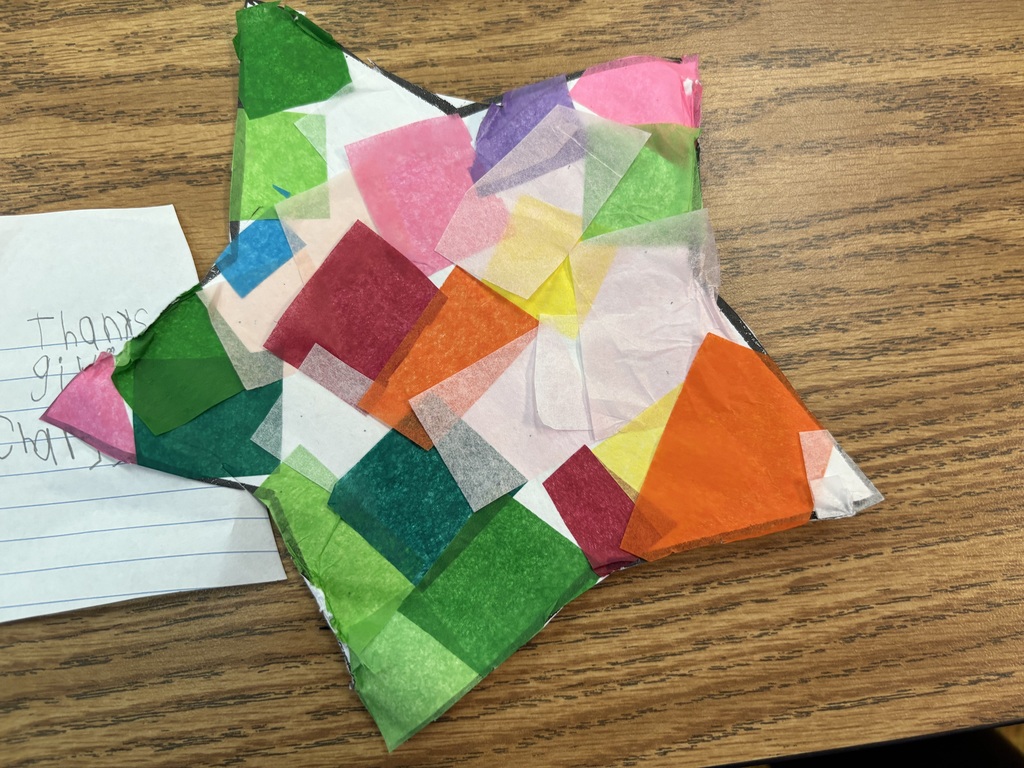 A stain glass being fashioned out of tissue paper. 