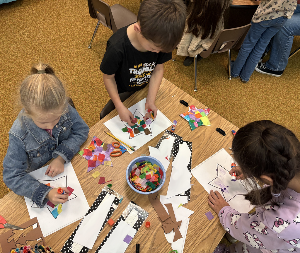 Students working on a stain glass being fashioned out of tissue paper. 
