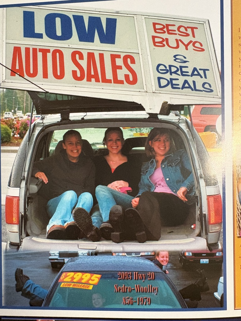 A yearbook advertisement featuring two Sedro-Woolley students who are now current district staff members, posing together in a playful photo from their high school years.