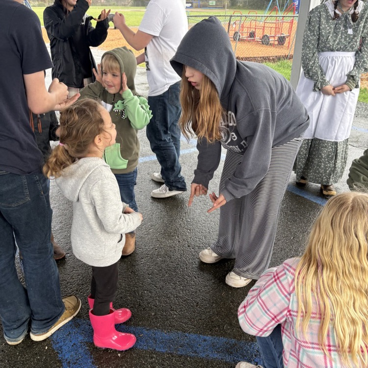 Students playing games under the covered play area. 