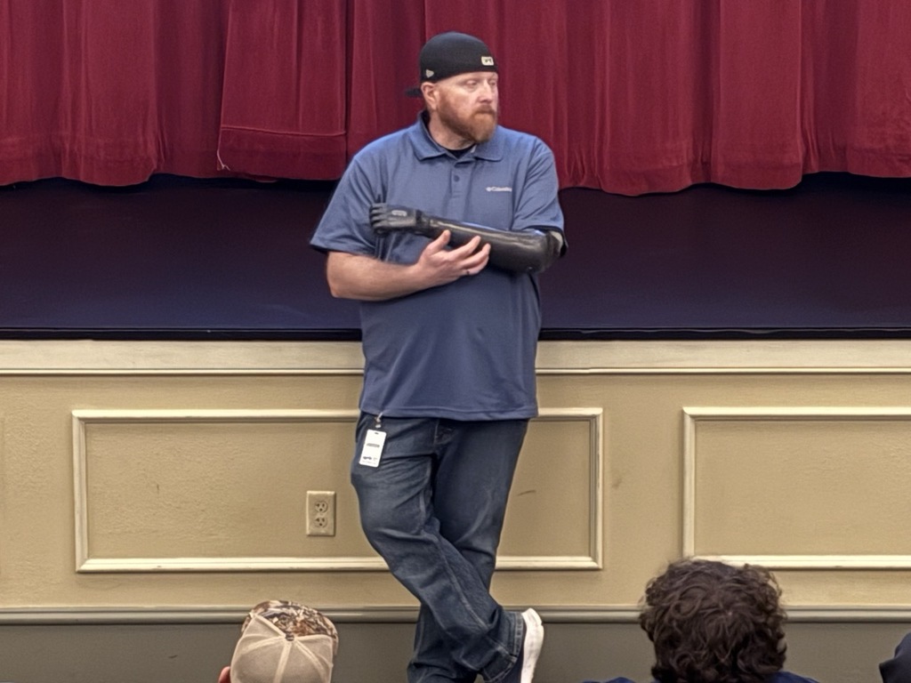Matt Pomerinke stands in front of the stage in the Sedro-Woolley High School auditorium speaking to students about workplace safety and sharing his personal story.
