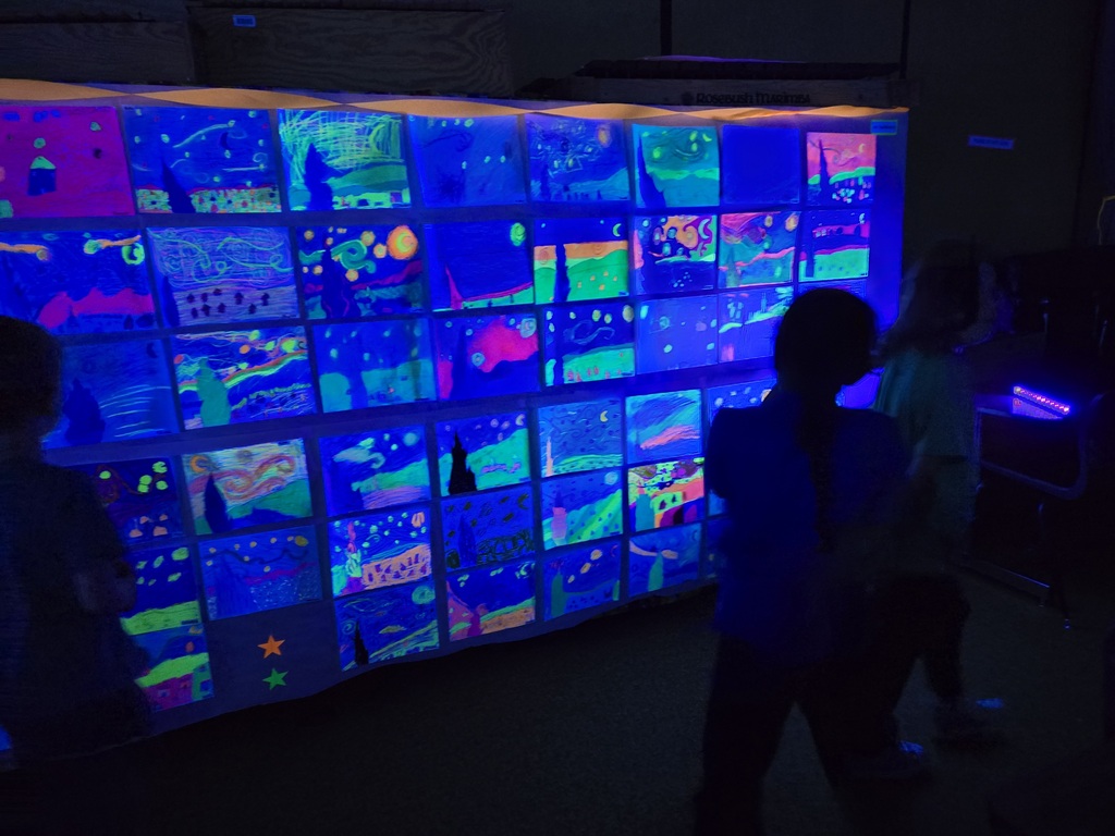 Students and families were able to explore glowing Vincent Van Gogh-inspired artwork during Evergreen STEM Elementary School’s art show and STEM Night. Displays feature colorful “Starry Night” and sunflower-themed student art illuminated under black lights.