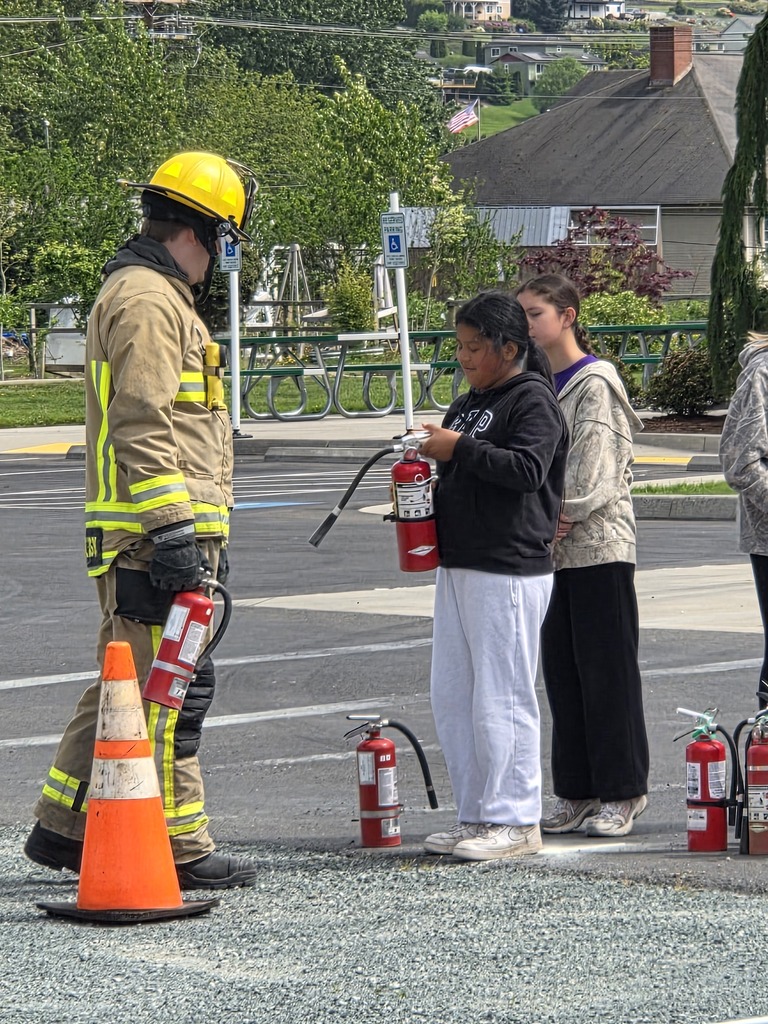 Big Lake Elementary School 6th grade students visit the Big Lake Fire Department to learn about fire safety and practice using fire extinguishers with the help of local firefighters. Students participate in hands-on activities and demonstrations during the educational field trip.