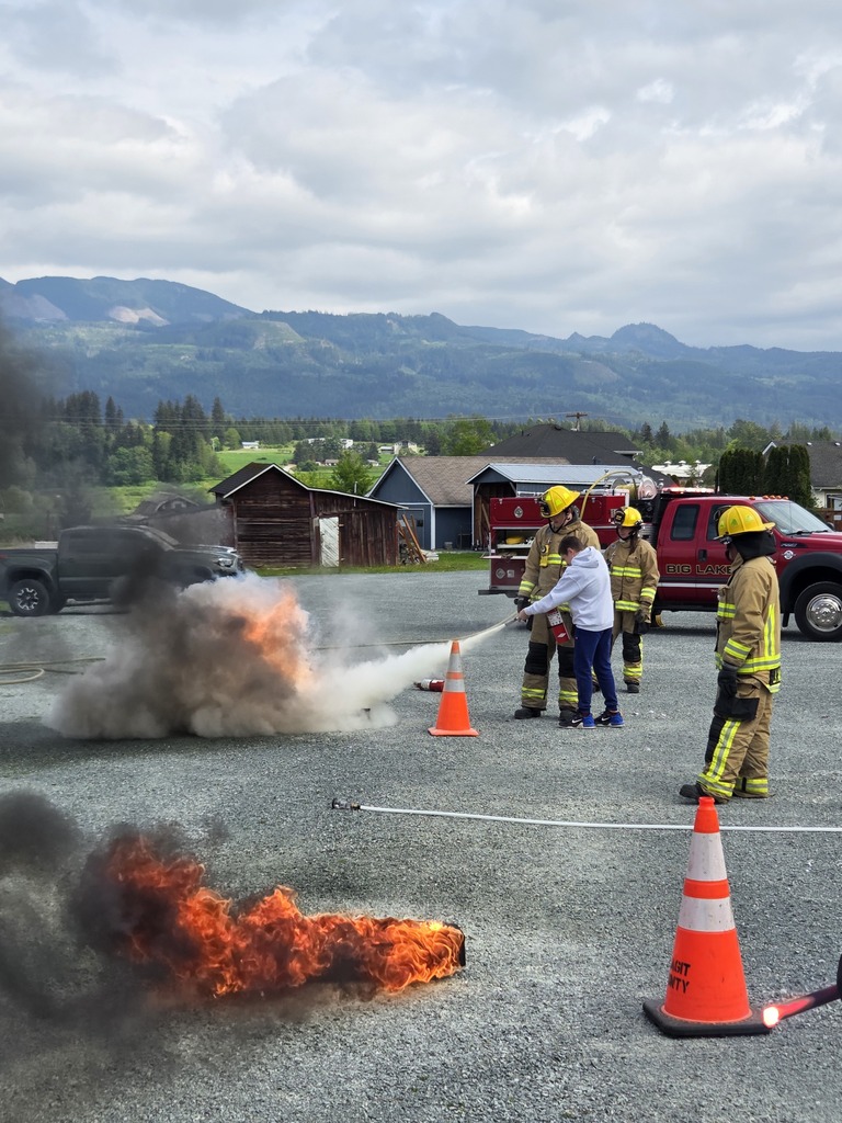 Big Lake Elementary School 6th grade students visit the Big Lake Fire Department to learn about fire safety and practice using fire extinguishers with the help of local firefighters. Students participate in hands-on activities and demonstrations during the educational field trip.