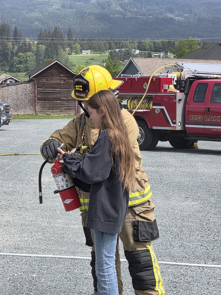 Big Lake Elementary School 6th grade students visit the Big Lake Fire Department to learn about fire safety and practice using fire extinguishers with the help of local firefighters. Students participate in hands-on activities and demonstrations during the educational field trip.