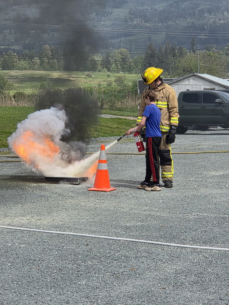 Big Lake Elementary School 6th grade students visit the Big Lake Fire Department to learn about fire safety and practice using fire extinguishers with the help of local firefighters. Students participate in hands-on activities and demonstrations during the educational field trip.