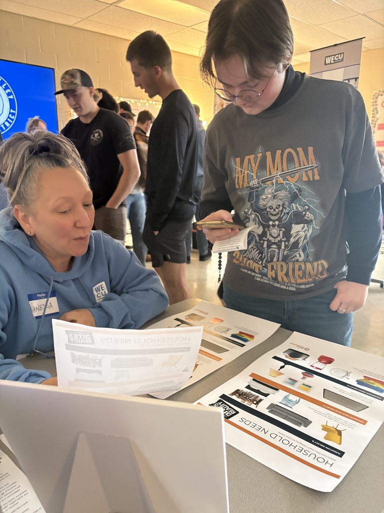 Sedro-Woolley High School students participate in the “Bite of Reality” financial simulation while speaking with WECU volunteers at different budgeting stations. Students review financial information, ask questions and make decisions about real-world expenses such as housing, transportation, groceries and childcare during the hands-on financial literacy activity.