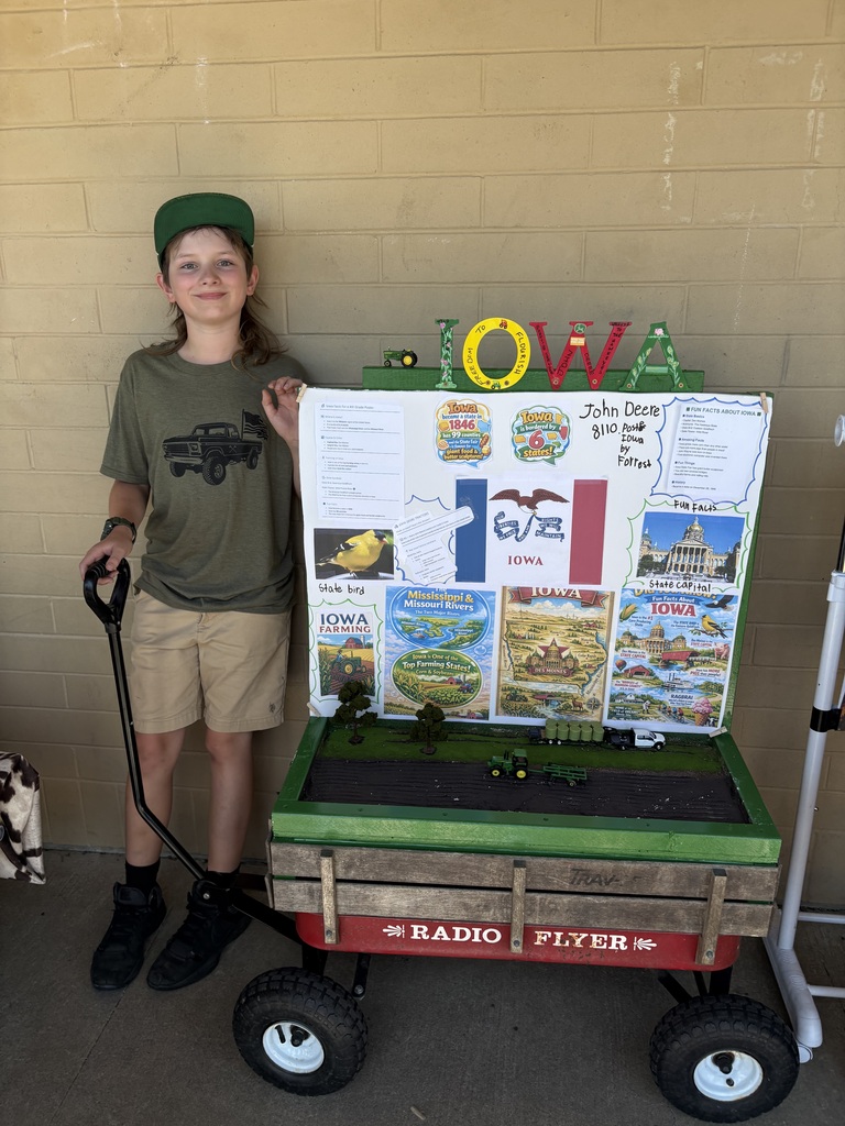 Evergreen STEM Elementary fourth grade students stand beside colorful state-themed floats they created for the annual Float Parade. The projects feature maps, landmarks, state symbols, and other research-based displays as students share information about their assigned states with visitors.