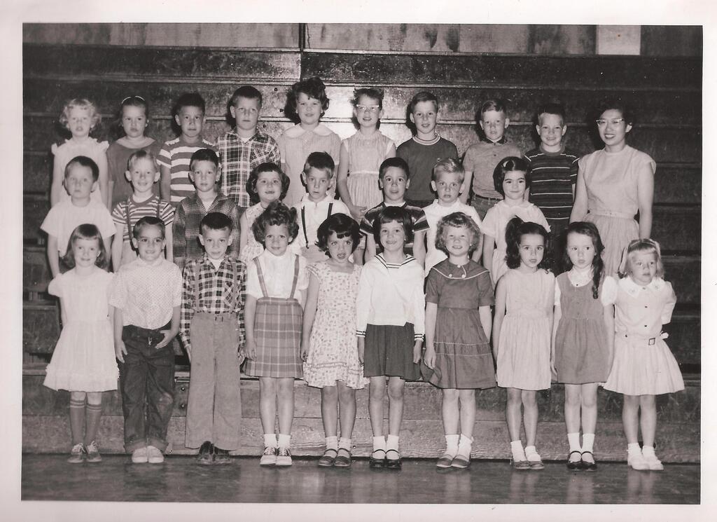Black-and-white 1958–59 Central School kindergarten class photo. About two dozen children pose in three rows in a school gym with their teacher, Mrs. Matsushita, standing at the right. The class attended Central during the school year when Alaska and Hawaii became states.